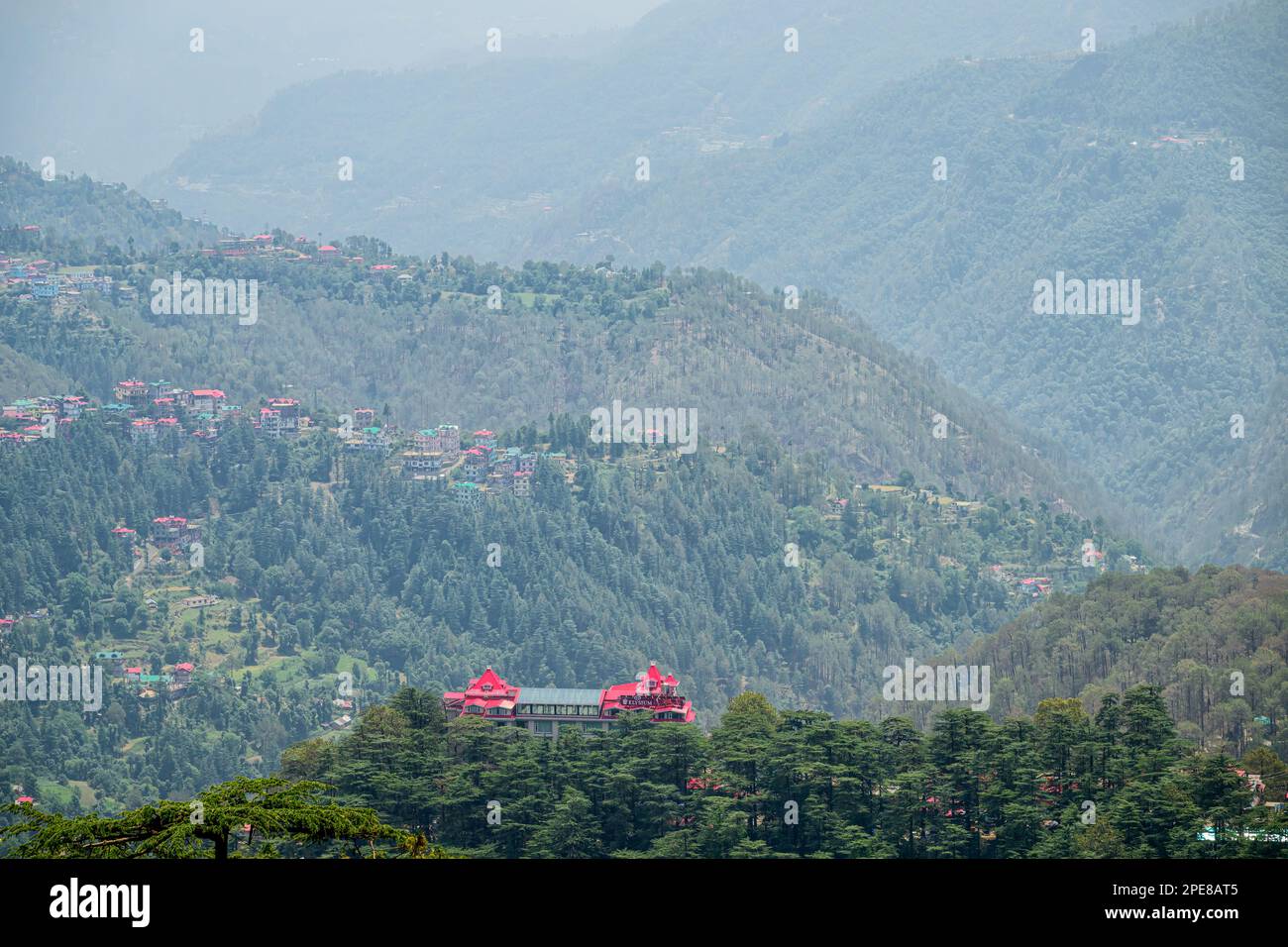 The classic colonial architecture of the Heritage Elysium Resort & Spa stands out on Station hill surrounded by the lush green valleys of Shimla Stock Photo