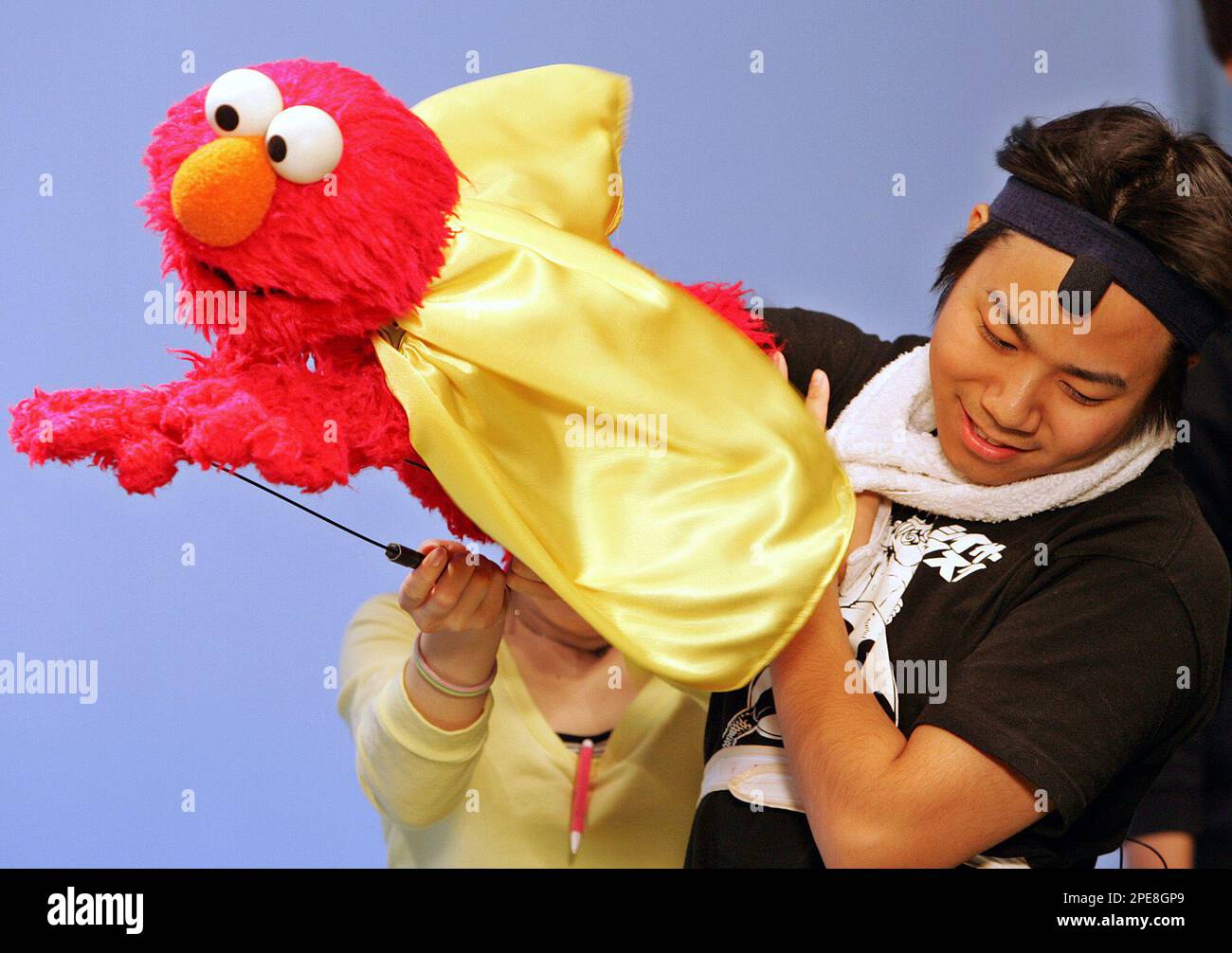 Kenta Matsumoto, a Muppet operator, handles Elmo, a popular Sesame Street  character, during a TV show filming at a Tokyo studio Wednesday, March 23,  2005. Some signs are in Japanese and the