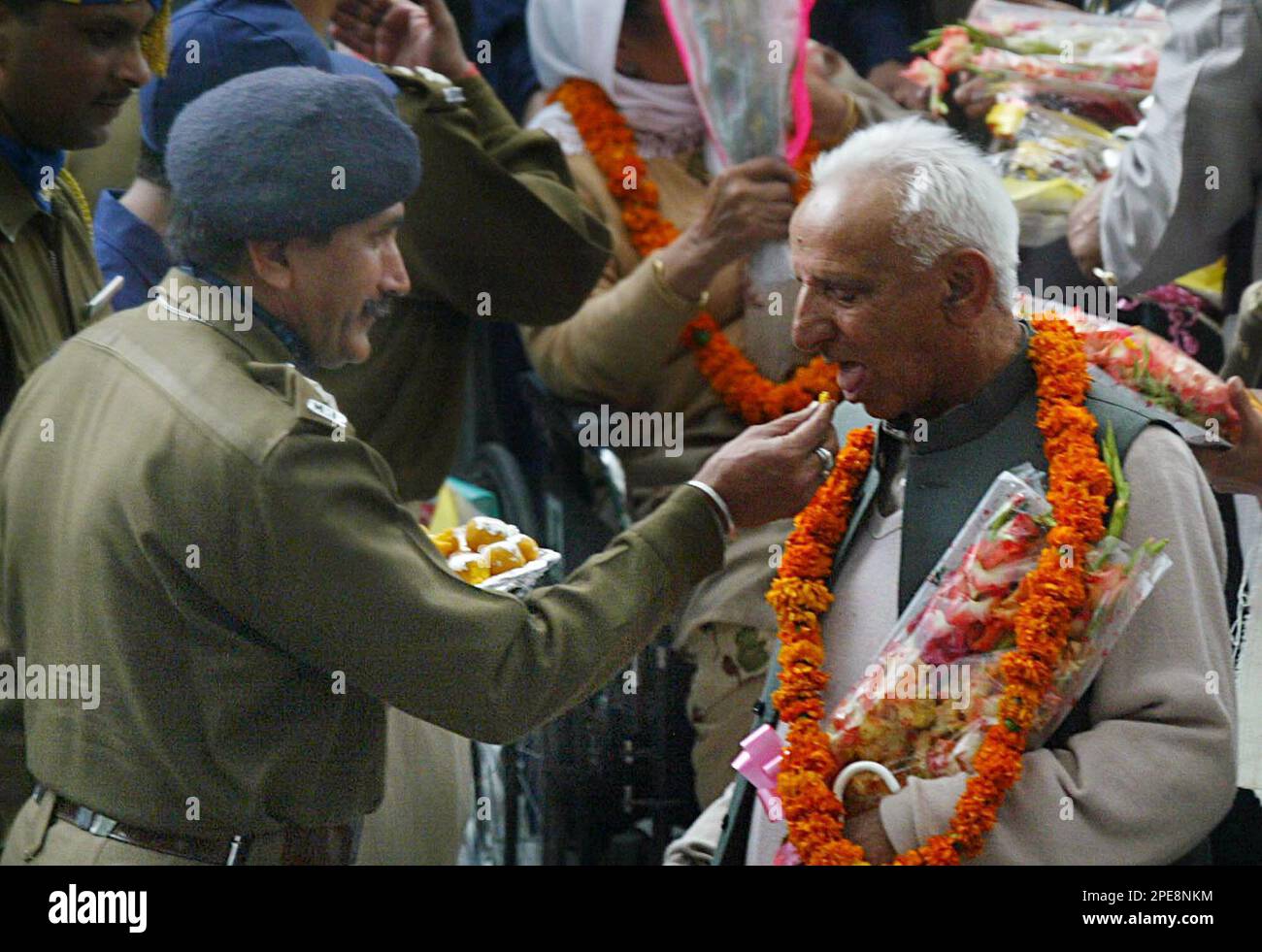 An indian army officer offer sweet to a bus passenger who arrived from