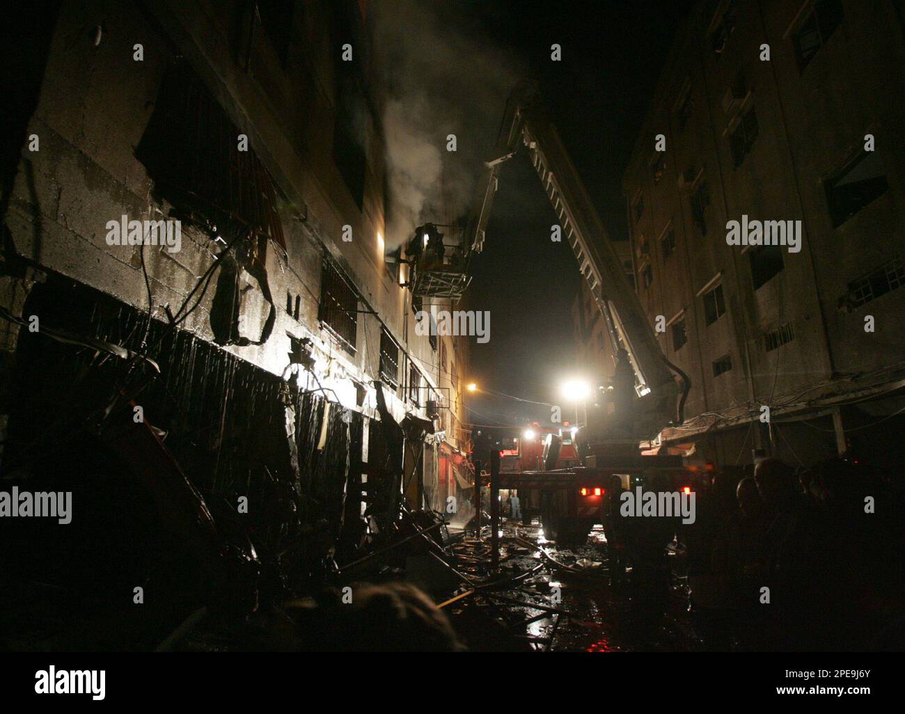Rescuers and firemen try to extinguish a fire in buildings at the site ...