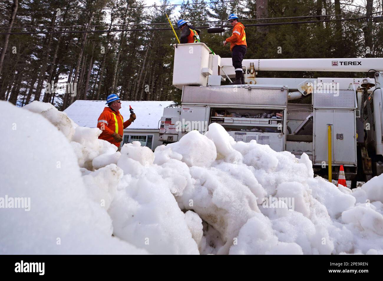 Linemen from Canada work to restore power to a neighborhood of about 70