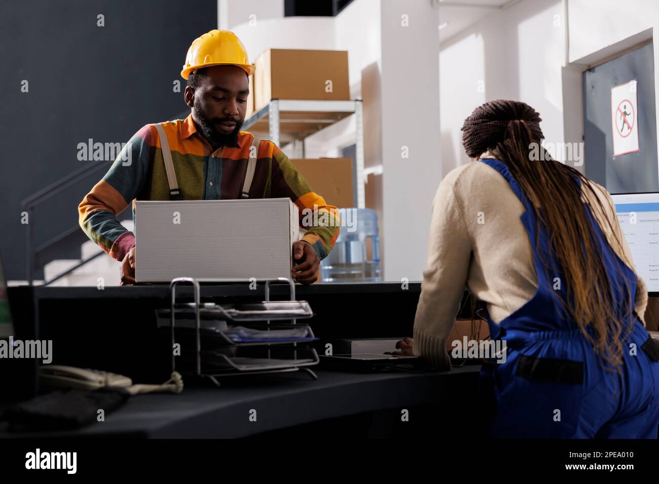 African american package handler putting packed parcel for shipment on