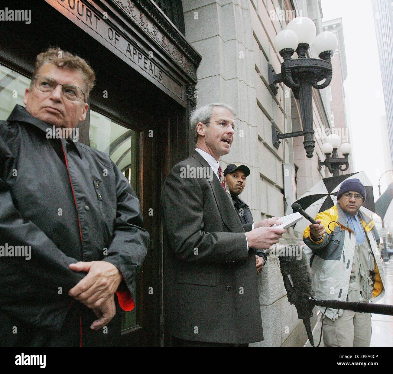Matt Davidson, court calendar clerk, is flanked by two Federal Protective  Service officers as he tells members of the media that Michael Schiavo,  husband of Terri Schiavo, has filed a motion with