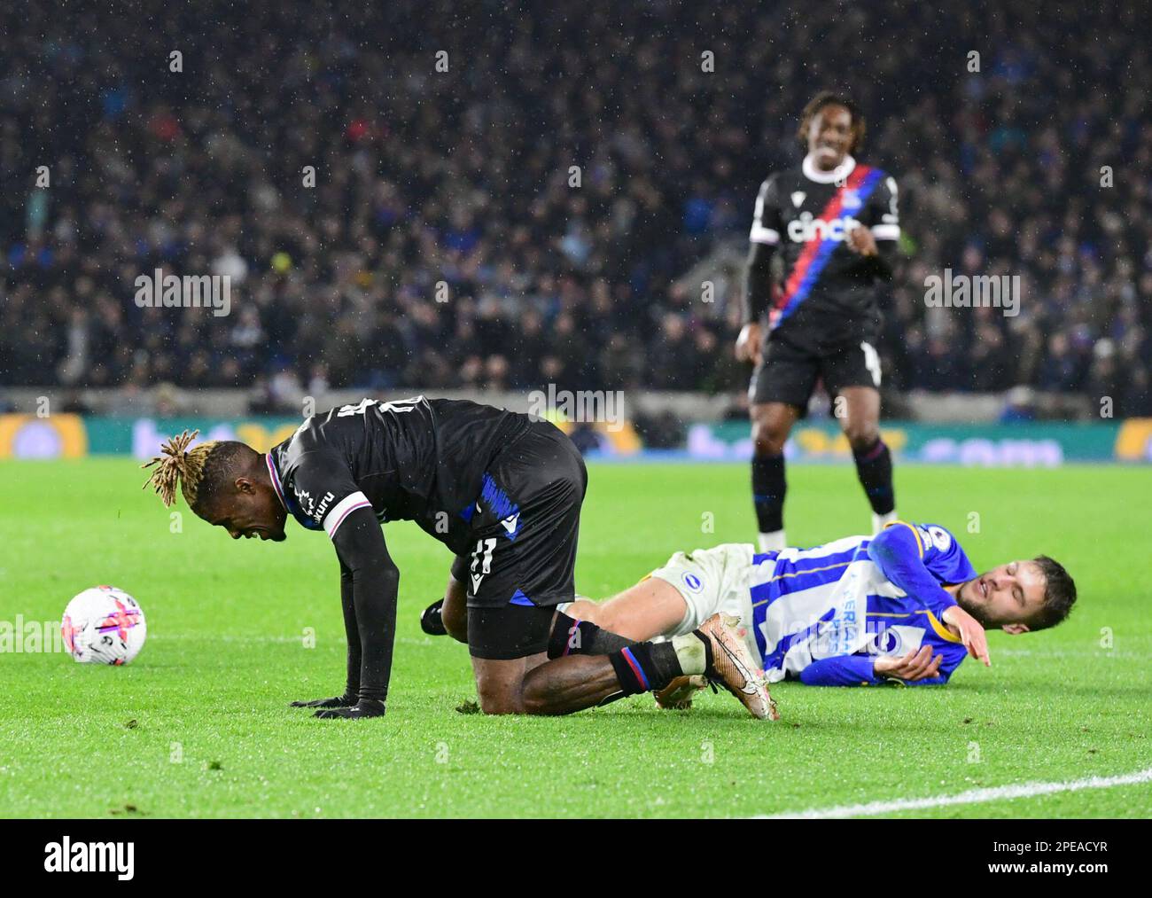 Wilfried Zaha of Crystal Palace and Joel Veltman of Brighton and Hove Albion both go to ground during the Premier League match between Brighton & Hove Albion and Crystal Palace at The Amex on March 15th 2023 in Brighton, England. (Photo by Jeff Mood/phcimages.com) Stock Photo