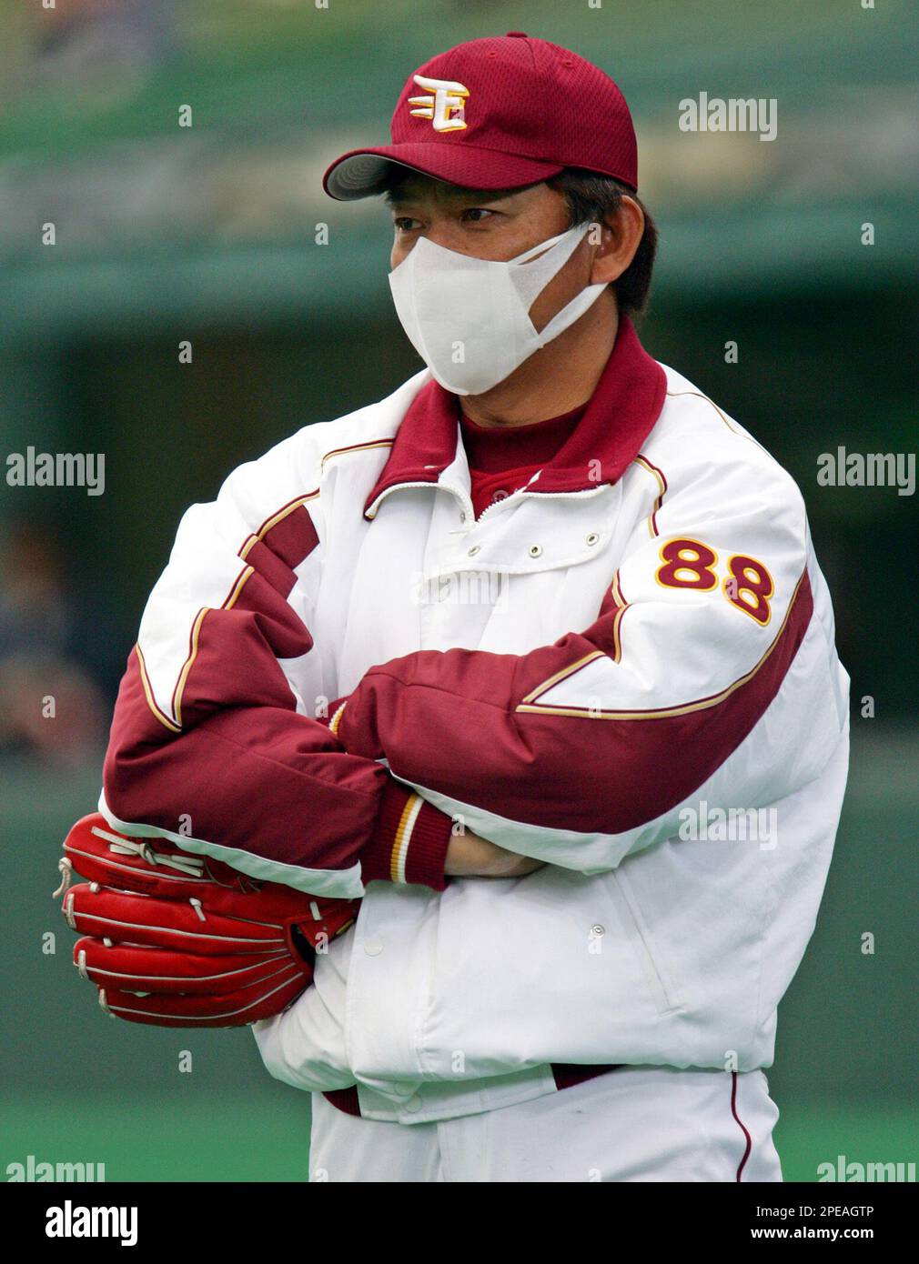 Tohoku Rakuten Golden Eagles manager Yasushi Tao wearing a mask watches the Japans brand new baseball teams workout prior to a spring game against the defending Japan Series champion Seibu Lions at
