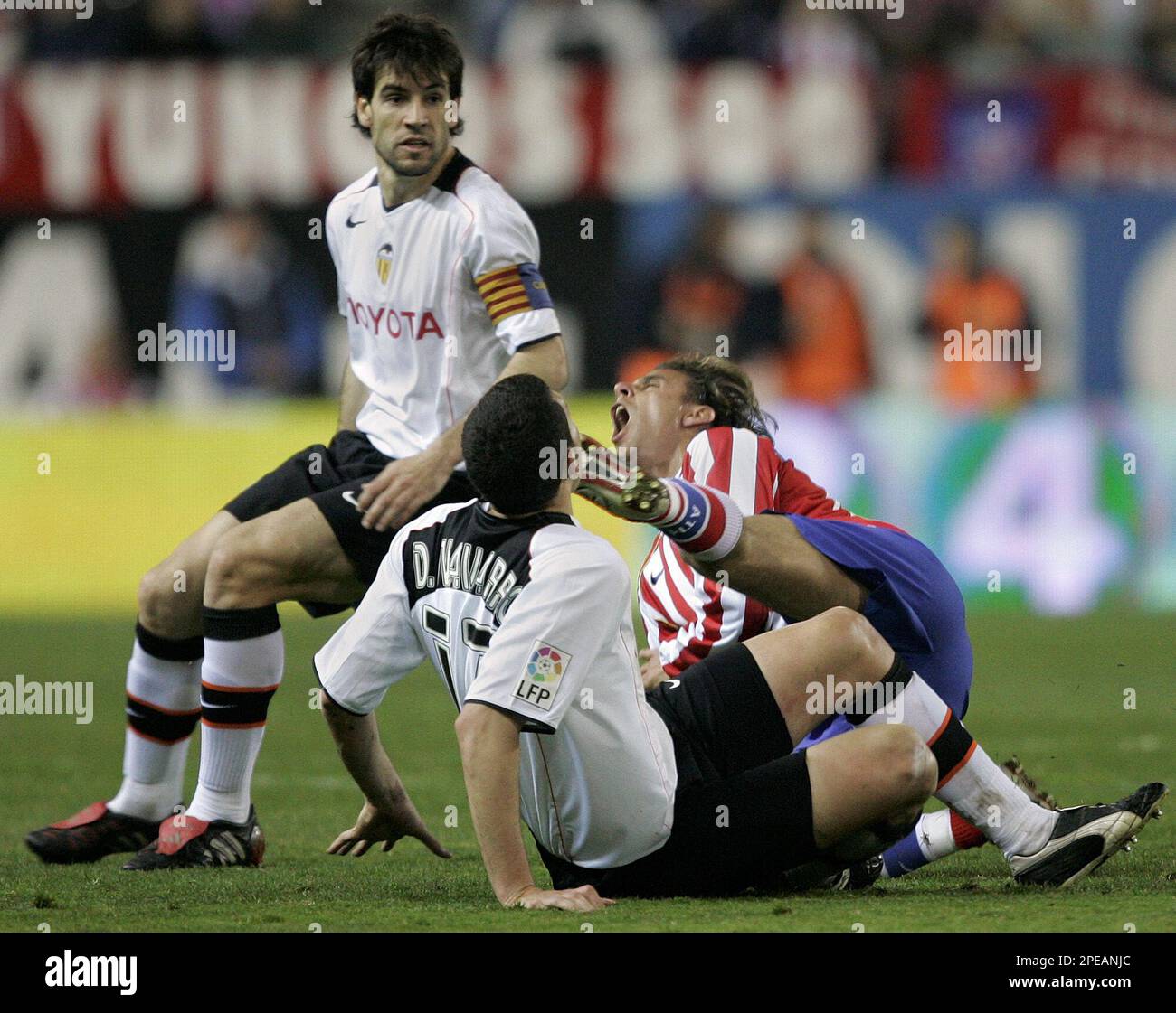 Atletico de Madrid player Richard Nunez from Uruguay, right, collides with Valencia player David Navarro Pedros from Spain, center, as Valencia team captain David Albelda Aliques from Spain, left, looks on during their Spanish league soccer match in Madrid, Sunday, March 13, 2005. Nunez had to abandon the game with a knee injury. Atletico de Madrid won the match with 1-0. (AP Photo/Jasper Juinen) ** EFE OUT ** Stock Photo