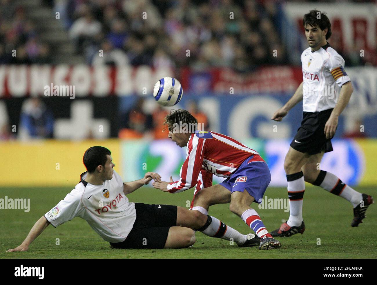 Atletico de Madrid player Richard Nunez from Uruguay, center, collides with Valencia player David Navarro Pedros from Spain, left, as Valencia team captain David Albelda Aliques from Spain, right, looks on during their Spanish league soccer match in Madrid, Sunday, March 13, 2005. Nunez had to abandon the game with a knee injury. Atletico de Madrid won the match with 1-0. (AP Photo/Jasper Juinen) ** EFE OUT ** Stock Photo