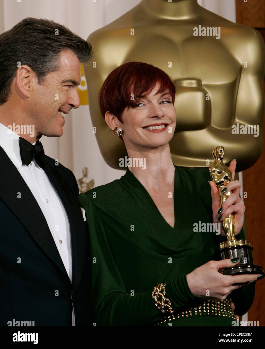 Sandy Rauch Sandy Powell looks up at actor Pierce Brosnan as she poses with the ...