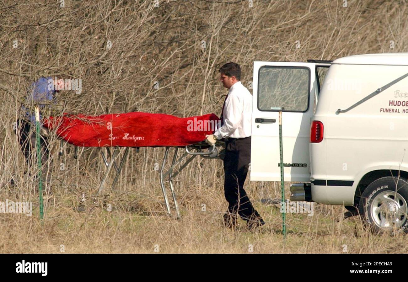 Funeral directors wheel a body from the brush in a rural area near Northlake, Texas, Tuesday, Feb. 22, 2005. A pregnant woman, Lisa Underwood, and her 7-year-old son, Jayden, disappeared Saturday. Stephen
