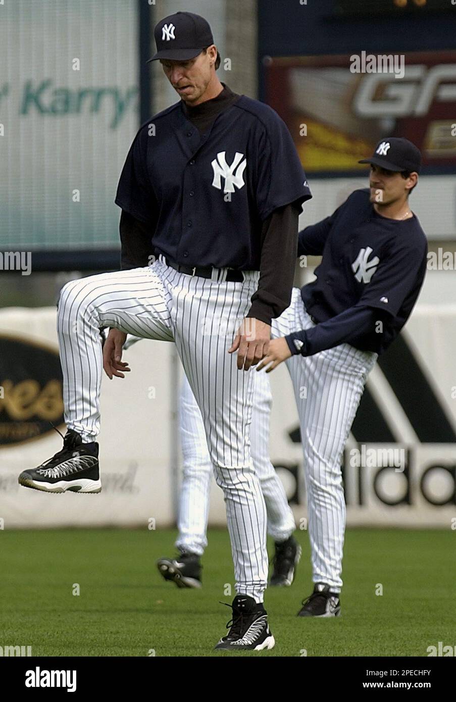 New York Yankees pitchers Randy Johnson, front and Carl Pavano, background,  raise their legs as they stretch at the start of workouts at spring  training, Tuesday, Feb. 22, 2005, in Tampa, Fla. (