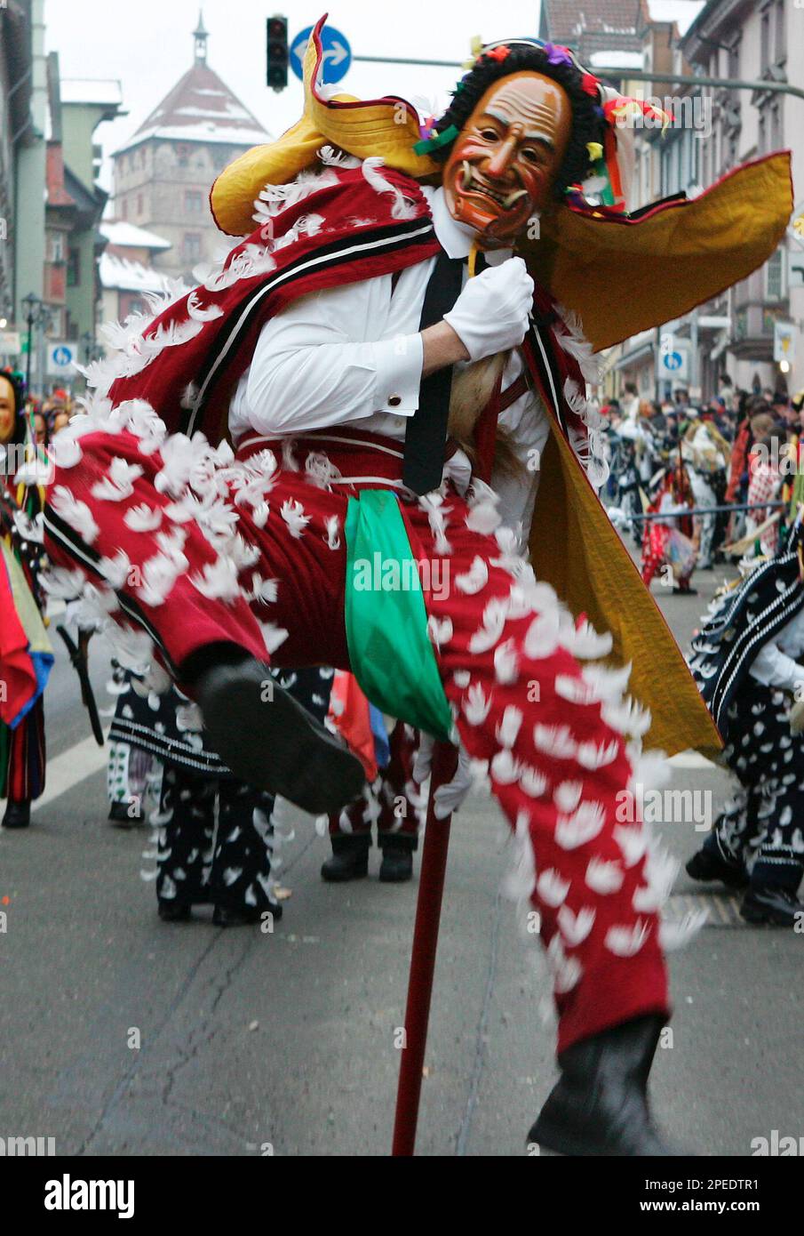 Ein "Federahansel", eine der klassischen Figuren der Rottweiler Fasnacht, springt am Rosenmontag, 7. Feb. 2005, mit seinem Stock beim "Rottweiler Narrensprung". Zehntausende von Besuchern saeumten den farbenpraechtigen Zug von etwa 3000 Kleidlestraegern durch die Rottweiler Altstadt. (AP Photo/Winfried Rothermel)- --A carnivalist dressed in a "Federahansel " (Feather Jack) costume uses a stick to jump during the traditional "Rottweiler Narrensprung" (Rottweil Fools Jump) in downtown Rottweil, southern Germany, on Monday, Feb. 7, 2005. Some 3000 carnival fools in the traditional costumes of the Stock Photo