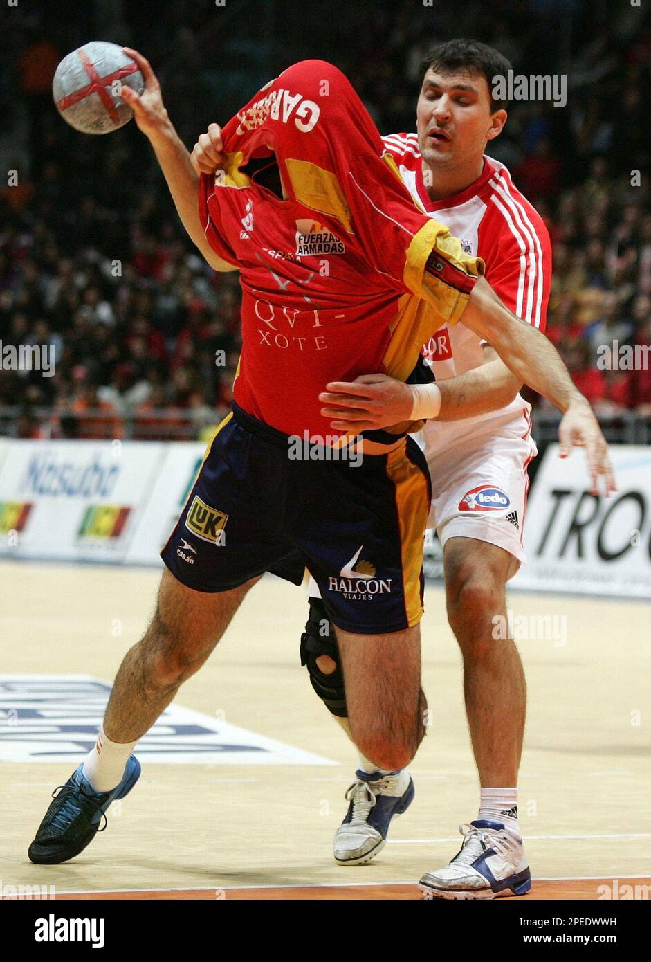 RETRANSMITS TO CORRECT NAME OF SPANISH PLAYER --Croatia's handball player  Petar Metlicic, right, pulls on the shirt of Spain's Ruban Garabaya,  center, during the final match at the 19th World Handball Championship