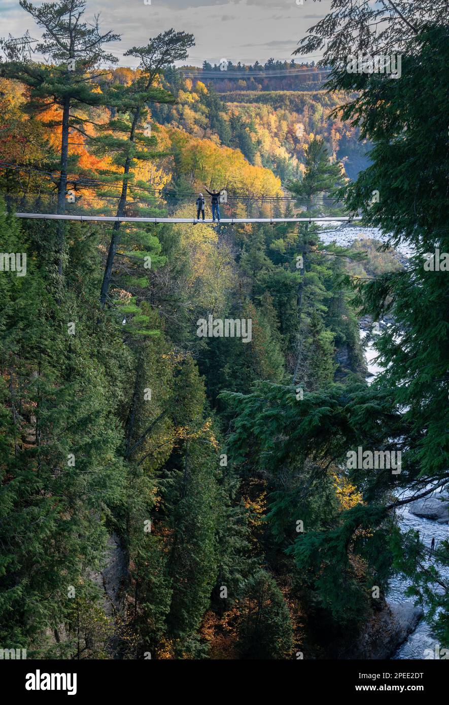 Tourists standing on one of two suspension bridges spanning the depths