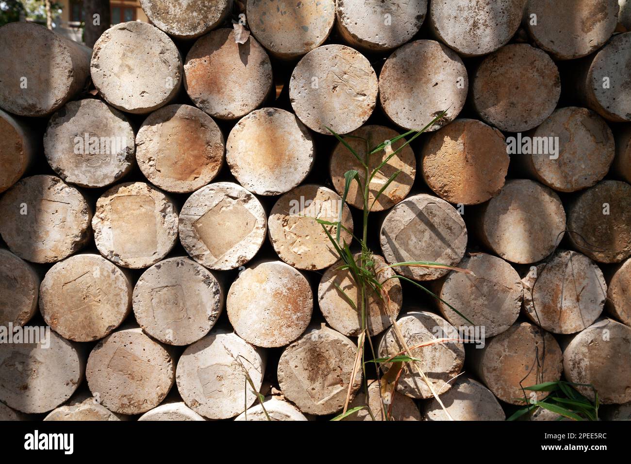 Pile of concrete piers for foundation repair stored outdoors, at a