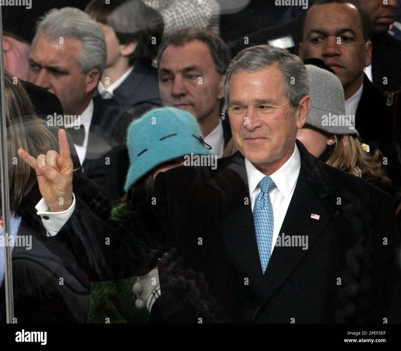 President Bush gestures the ""Hook 'em, 'horns" salute of the University of Texas Longhorns as he and his family watch the Inaugural Parade Thursday Jan. 20, 2005, in Washington. President Bush's "Hook 'em, 'horns" salute got lost in translation in Norway, where shocked people interpreted his hand gesture during his inauguration as a salute to Satan. (AP Photo/J. Scott Applewhite) Stock Photo