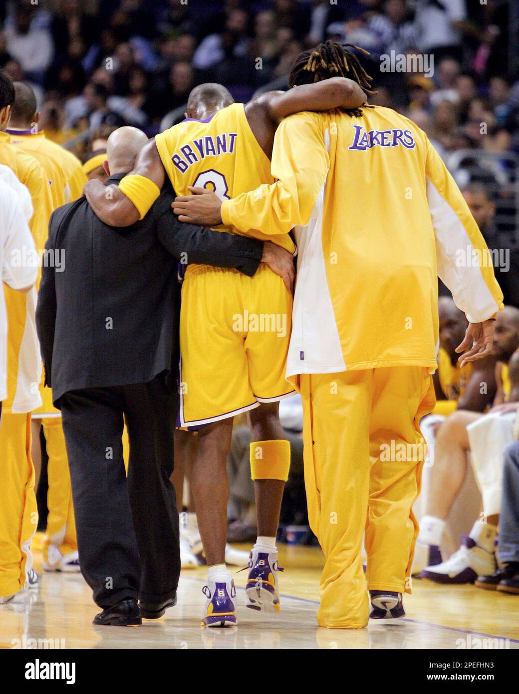 Los Angeles Lakers Kobe Bryant is helped off the floor by trainer Gary Vitti left and teammate Brian Grant after receiving a severe sprain to his right ankle during the first half