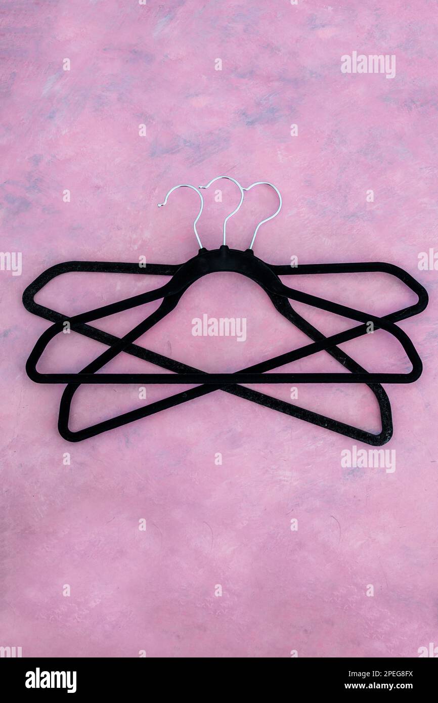 fashion and shopping concept, group of clothes hangers creating geometric shape on pink background Stock Photo