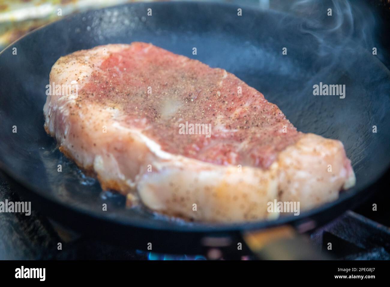 Searing a Ribeye Steak in a Wok Stock Photo