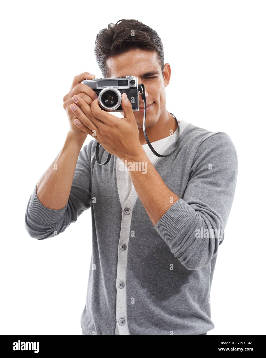 Capturing that special moment. Portrait of a young man holding a camera and taking pictures against a white background. Stock Photo