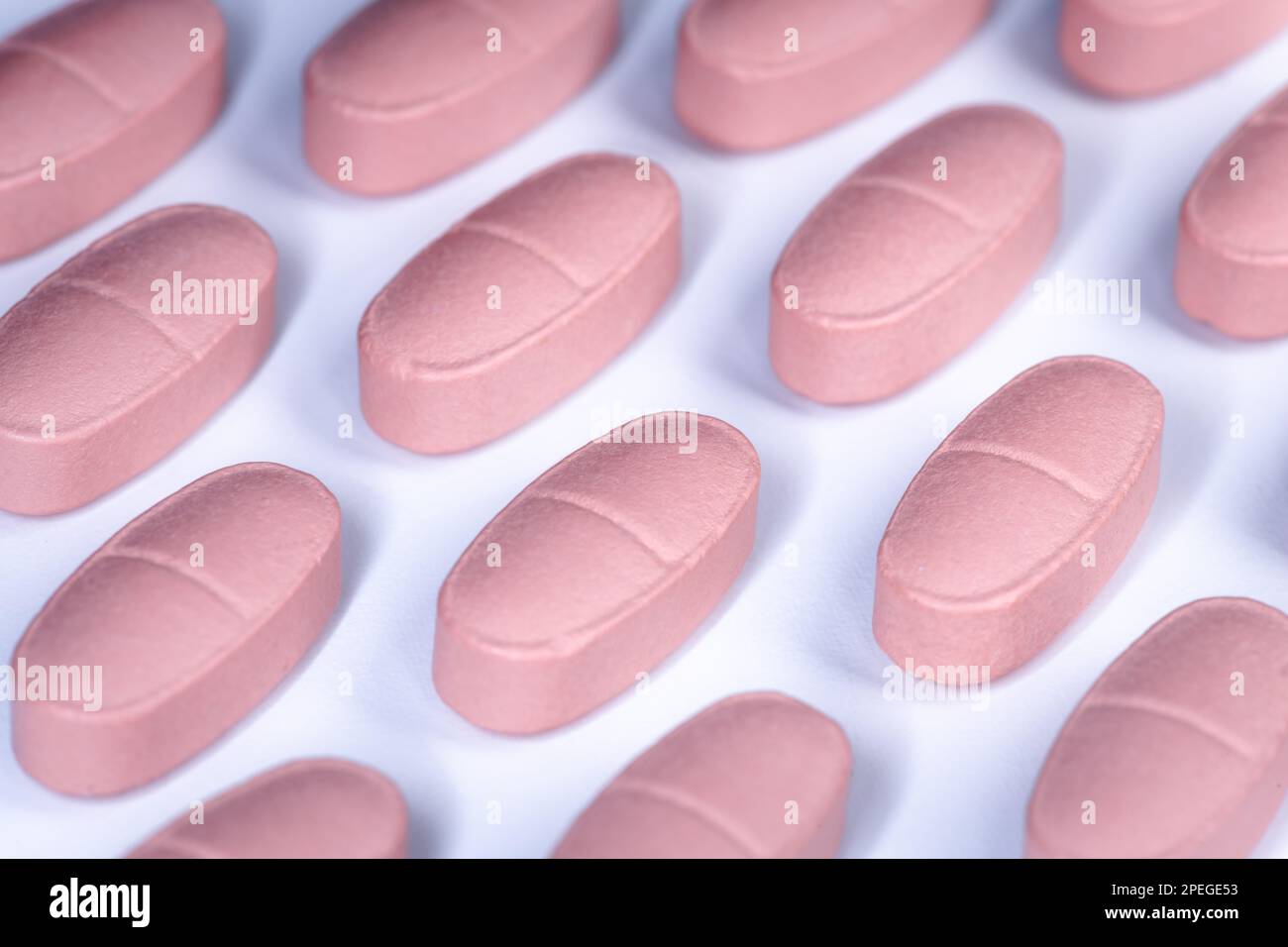 Spilled pink pills vitamins in rows background Stock Photo Alamy