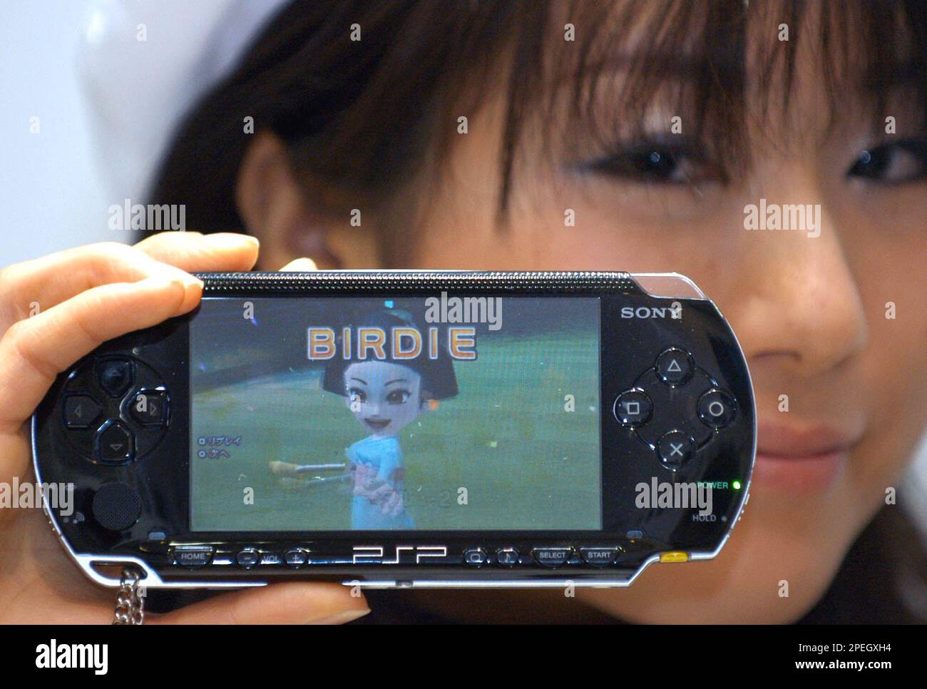 A model shows a PlayStation Portable (PSP) manufactured by Sony Computer  Entertainment, Sony Corp.'s video-game unit, at a Tokyo video shop as it  goes on sale in domestic market for 19,800 yen (