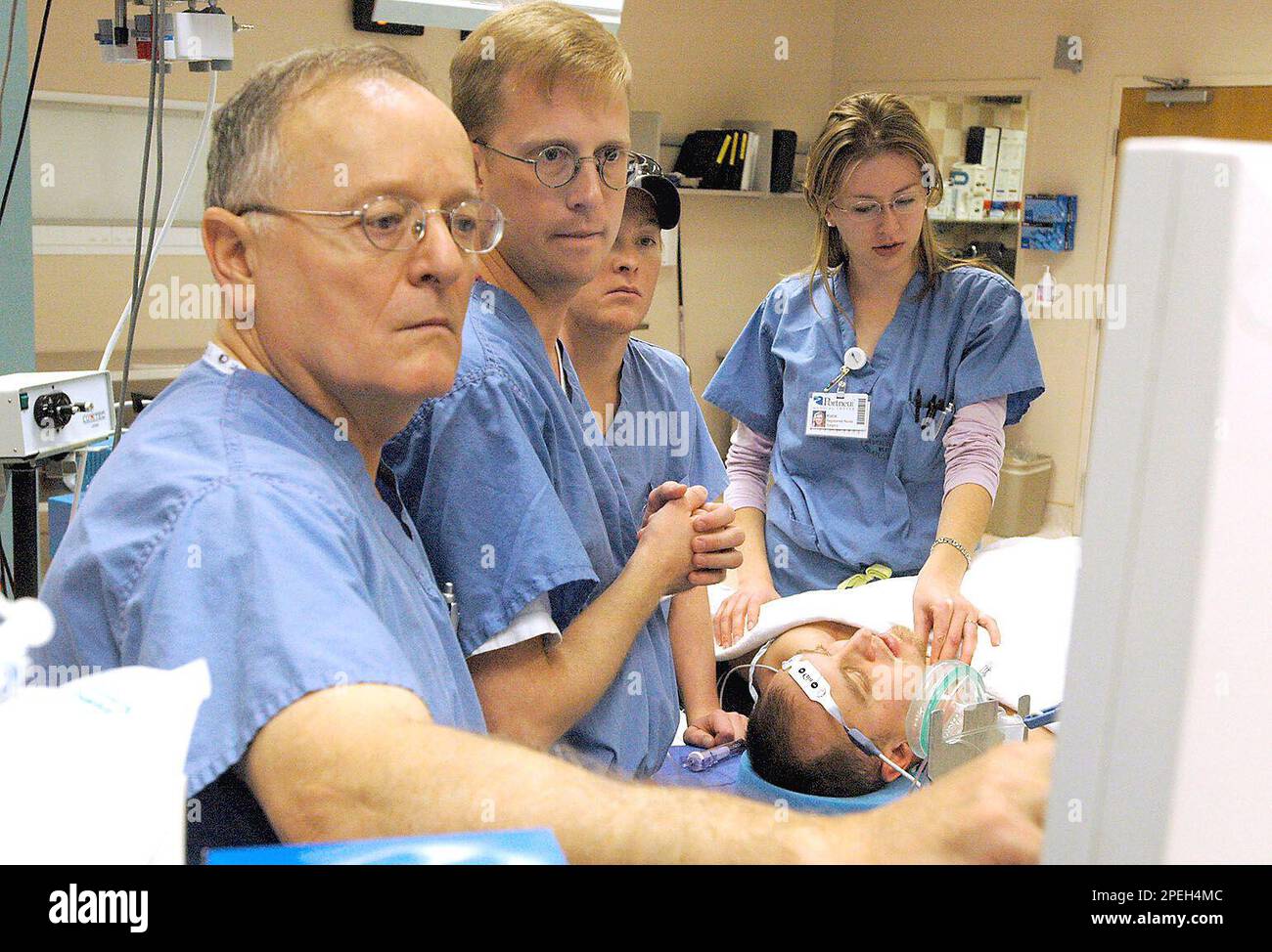 Checking the monitor during a mock mitral valve replacement procedure in the operating room of