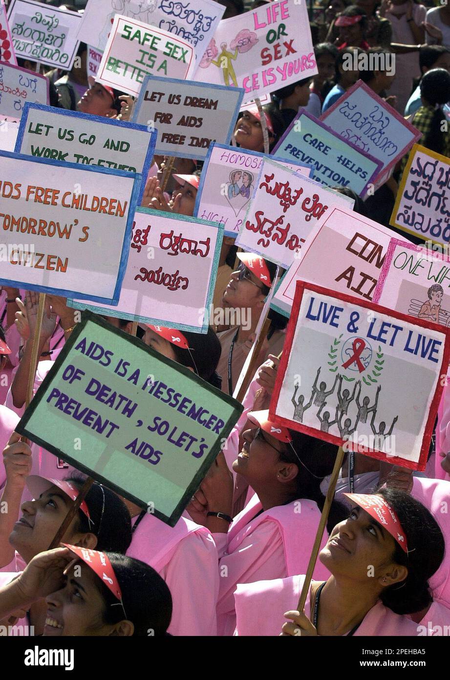 Students holding placards with AIDS awareness slogans look as balloons