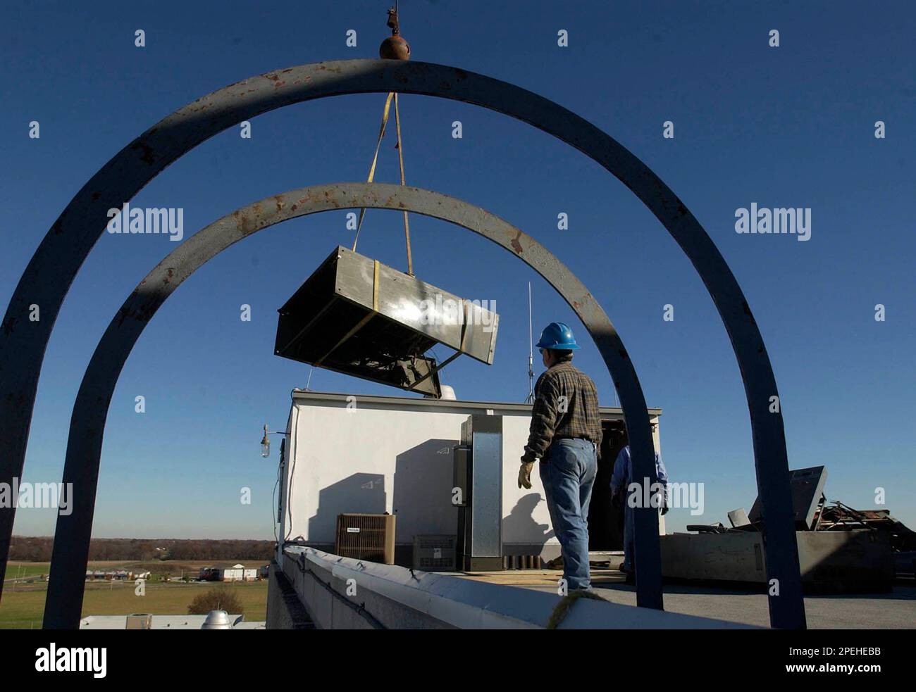 Seen through the handrails of a roof access ladder, Ronnie Outhier, a