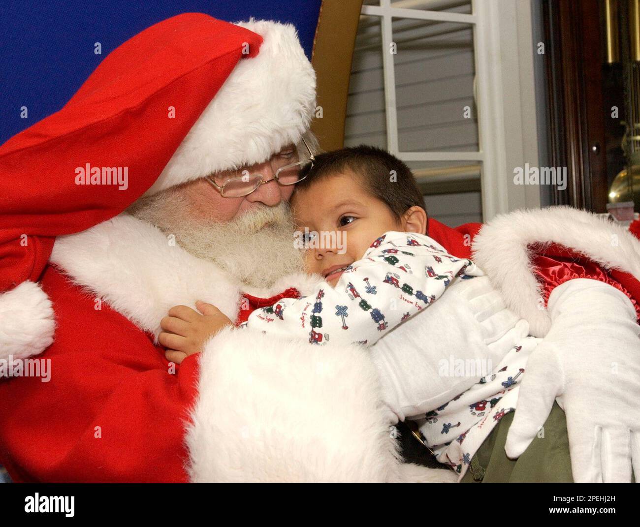 Andres Batther, 3, of Winton, gives Santa Claus a hug before telling ...