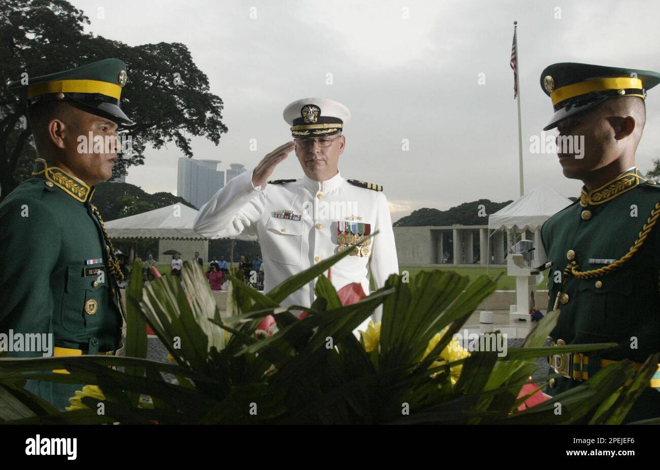 U.S. Navy Commander Brian Rinaldi salutes his wreath during a wreath ...
