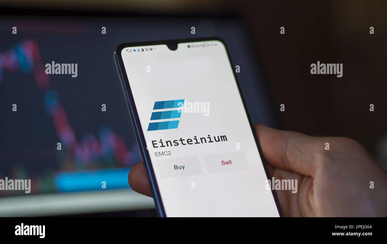An investor analyzing the  Einsteinium coin on screen. A phone shows the crypto's prices to invest in blockchain assets. Stock Photo