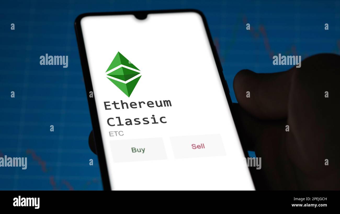 March 11 2023 London UK. An investor's analyzing the Ethereum Classic coin on screen. A phone shows the crypto's prices to invest in ETC Stock Photo