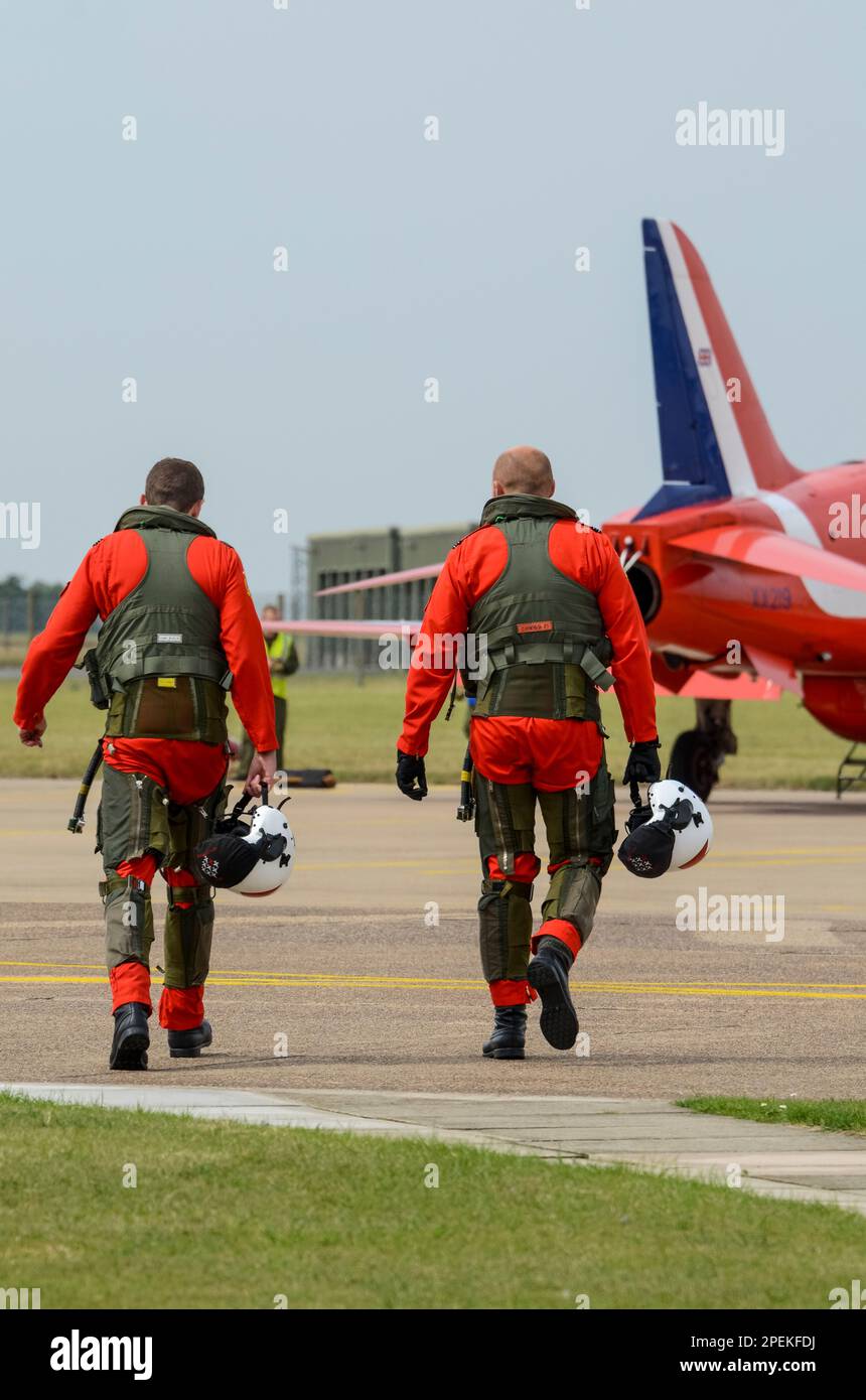Royal Air Force Red Arrows display team pilots walking out to BAe Hawk T1 jet plane prior to display at RAF Scampton. Wearing g suits & equipment Stock Photo