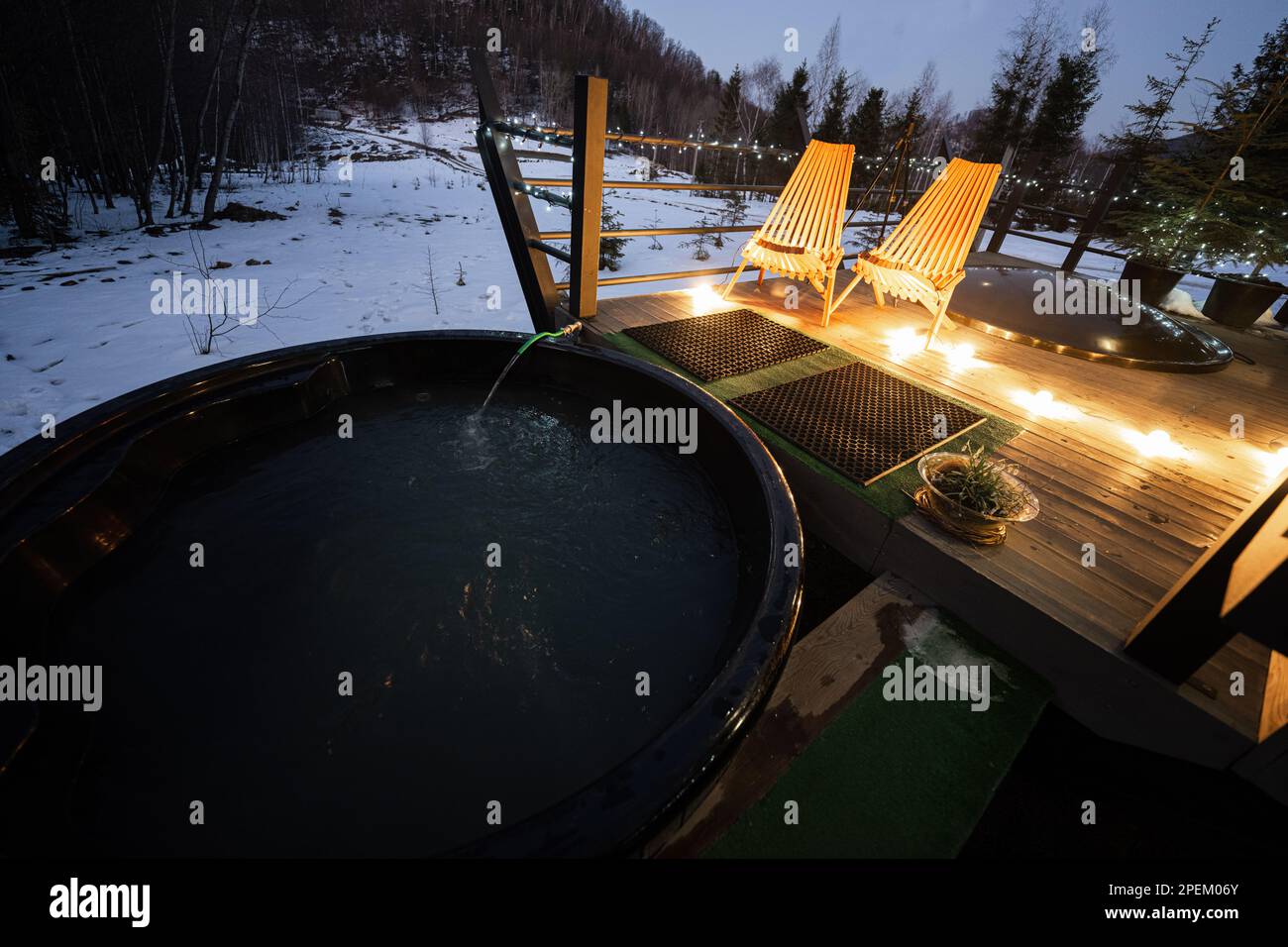 Picture of Wooden barrel hot tub in the terrace of the cottage at winter night ...
