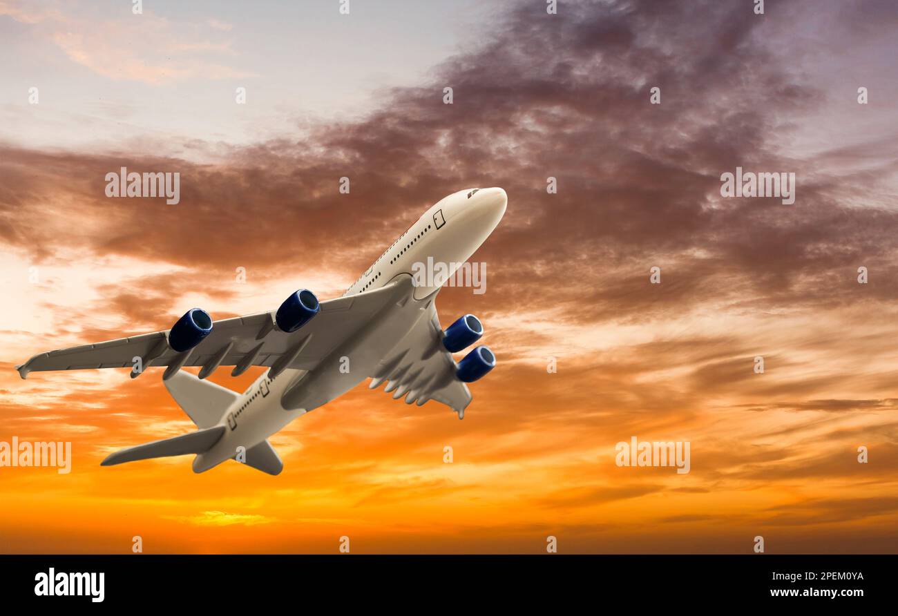 Commercial airplane flying above clouds in dramatic sunset light. Very ...
