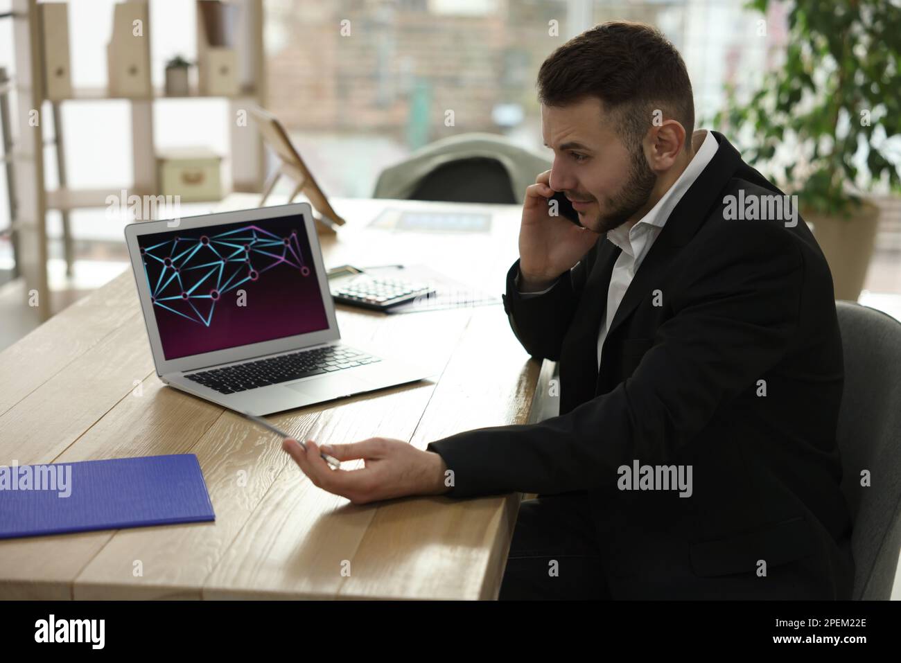 Stressed forex trader talking on phone while working in office Stock Photo