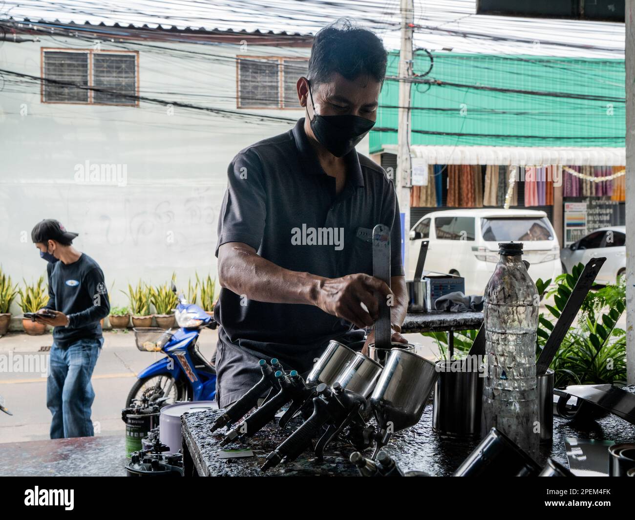 Bangkok, Thailand. 16th Mar, 2023. A worker at a spray paint shop mixes