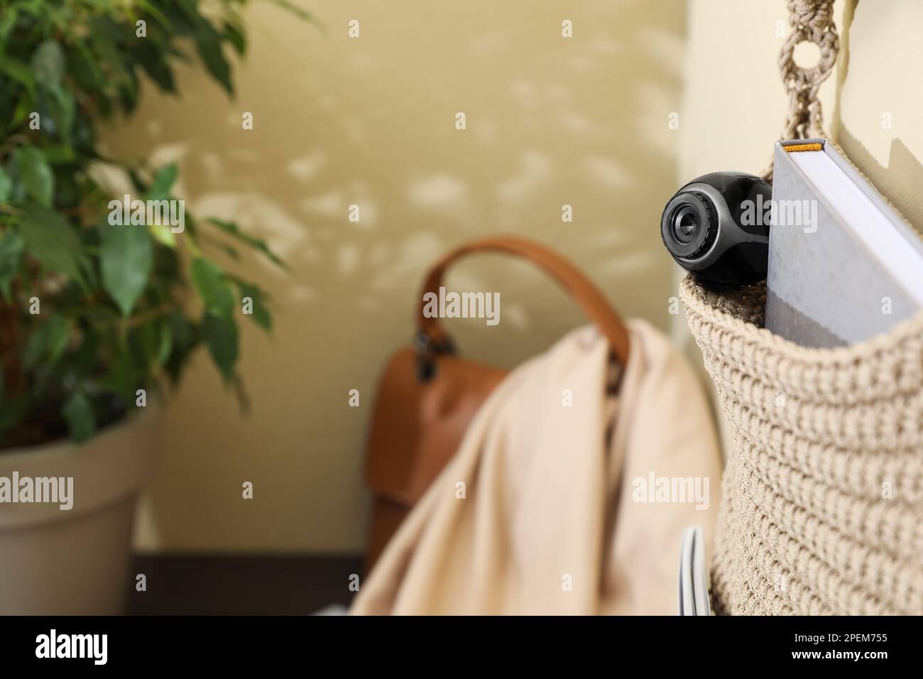 Hanging storage with small hidden camera on wall in room Stock Photo