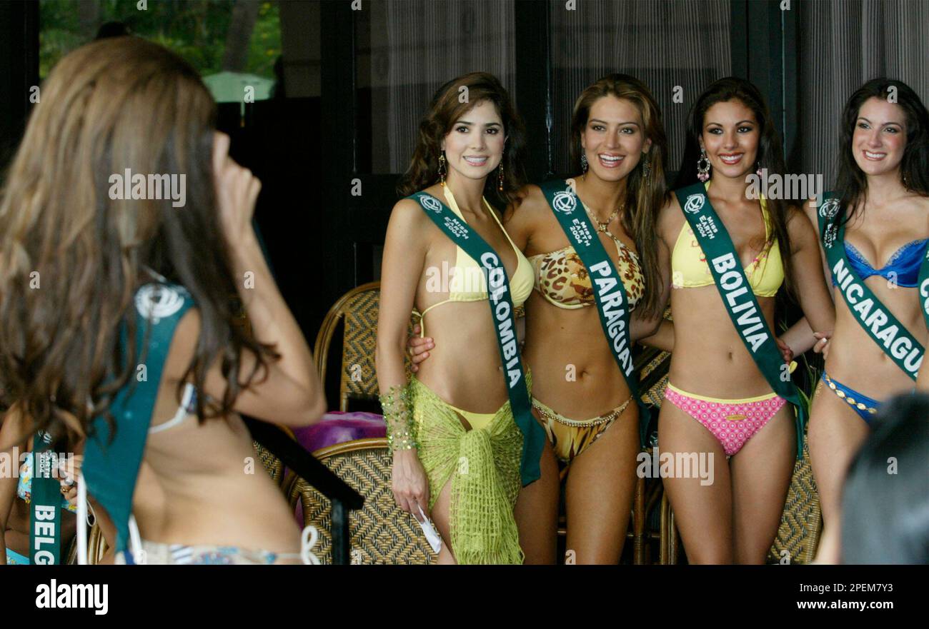 Nileny Esteves Dippton, left, of Dominican Republic, a contestant to the  Miss Earth 2004 beauty pageant, takes souvenir photos of fellow contestant  as they wait for their turn to be presented to