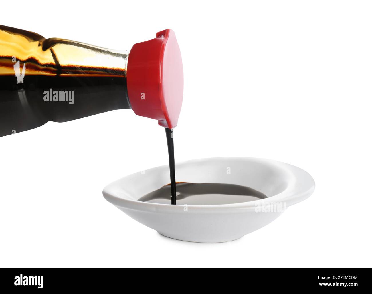 Pouring soy sauce into bowl against white background Stock Photo Alamy