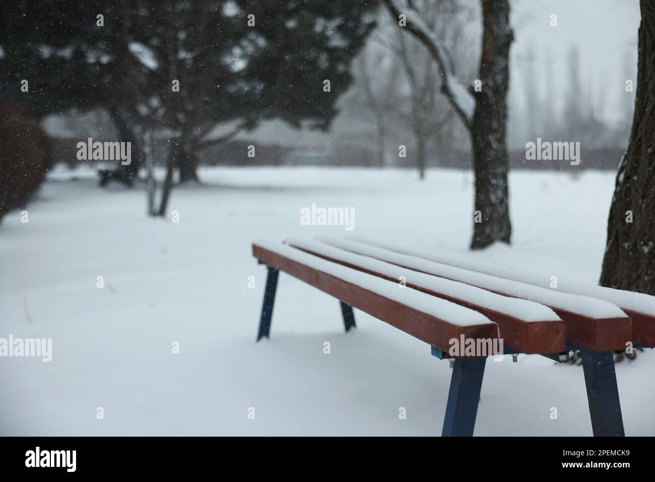 Bench covered with snow in city park Stock Photo - Alamy
