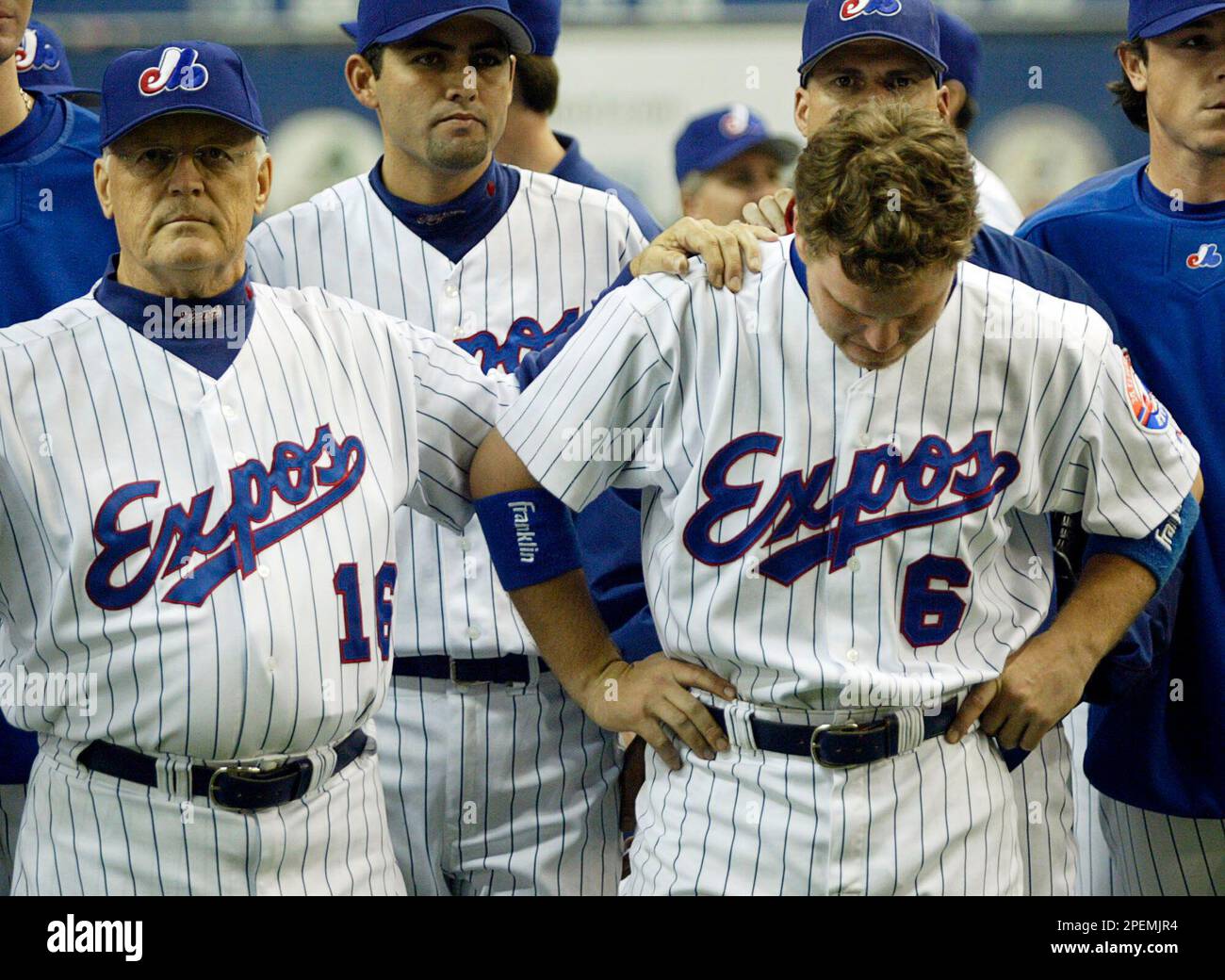 Montreal Expos former pitcher and now coach Claude Raymond, left, consoles  Brad Wilkerson as they say farewell to fans following the team's final home  game against the Florida Marlins in Montreal, Sept.