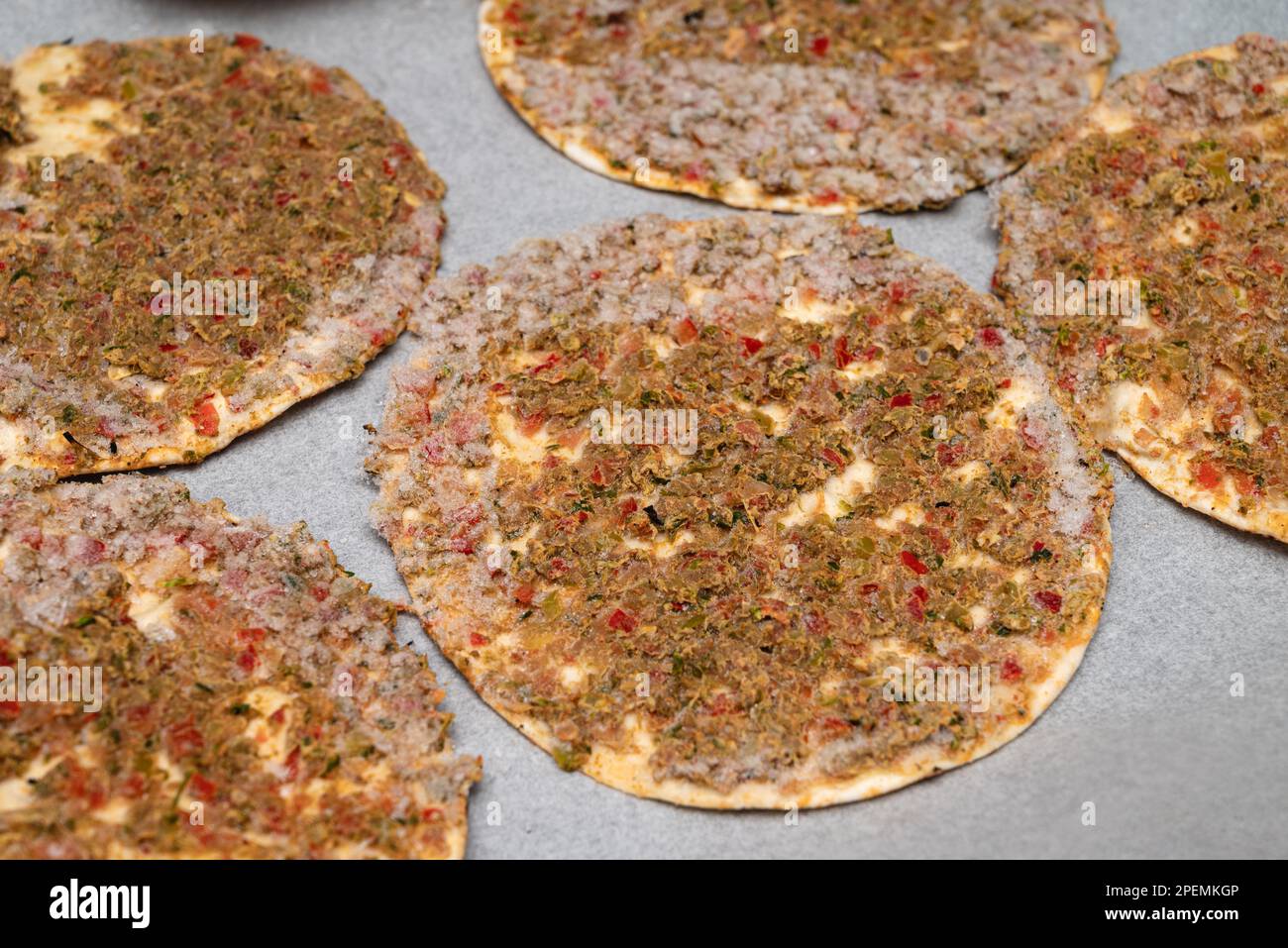 ready-to-eat frozen lahmacun on baking paper on a baking tray Stock Photo