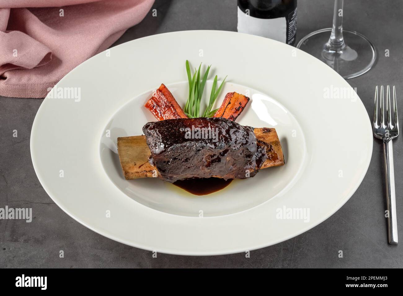 Long cooked marinated beef ribs on a white porcelain plate Stock Photo