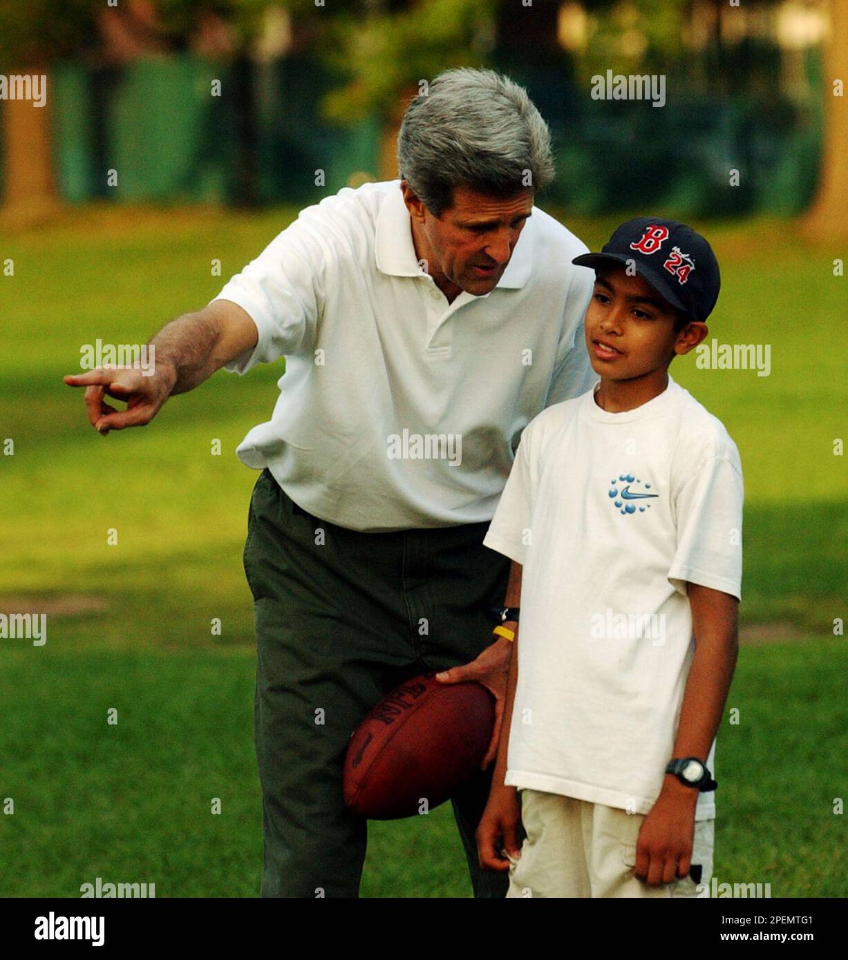 Democratic Presidential candidate Sen. John Kerry, D-Mass, calls out a play to Karan Singhal, 11, of Boston as he plays a game of football on the Esplanade in Boston Saturday, Sept. 25, 2004. (AP Photo/Gerald Herbert) Stock Photo