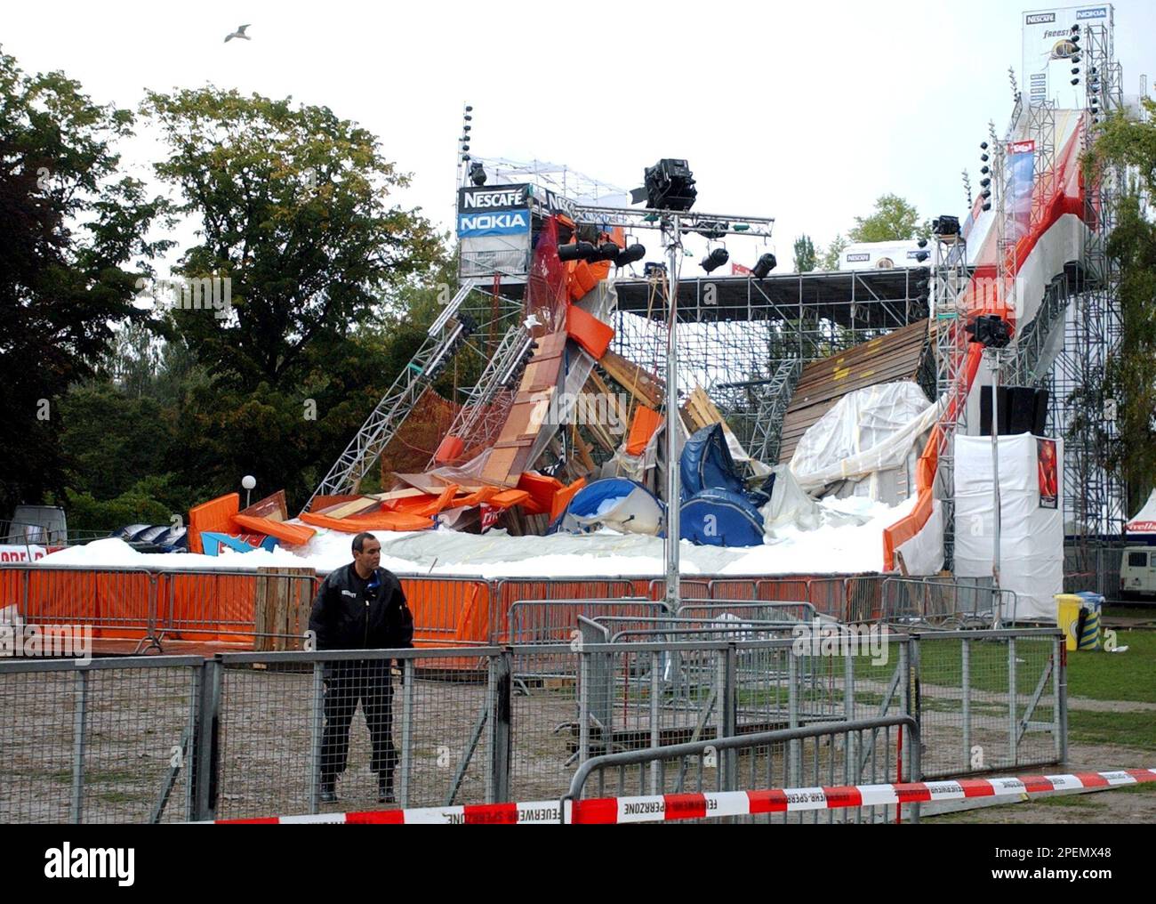 A security man stands in front of the collapsed ski jump of the  "freeystyle.ch" event at the Landiwiese festival place in Zurich,  Switzerland, Saturday, Sept. 25, 2004. The reason for the jumps