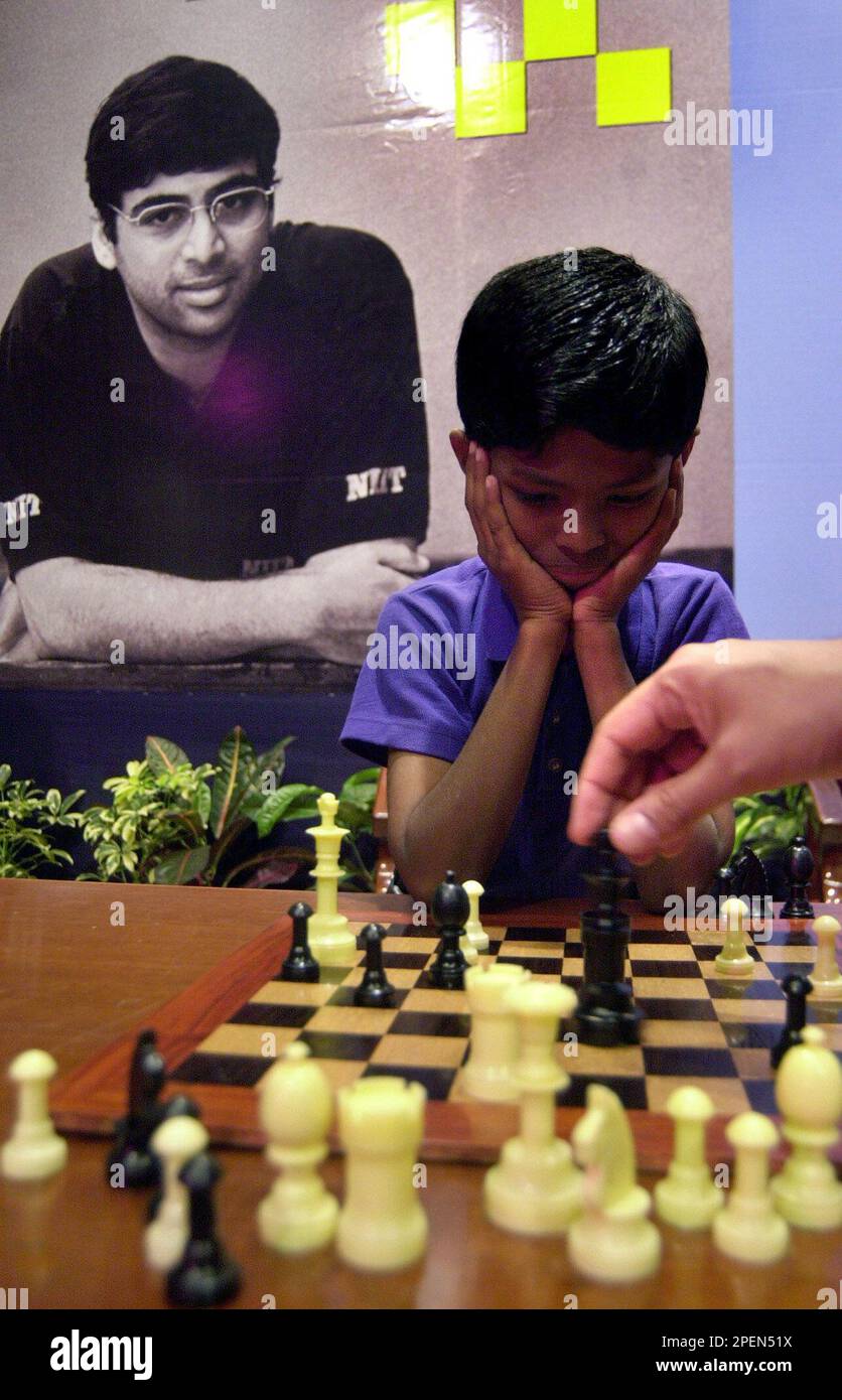 V. P. Kaushik, 11, watches as Indian World Rapid Chess Champion Viswanathan  Anand, unseen right, makes a move at the launch of a school chess  tournament organized by the NIIT Mind Champion's