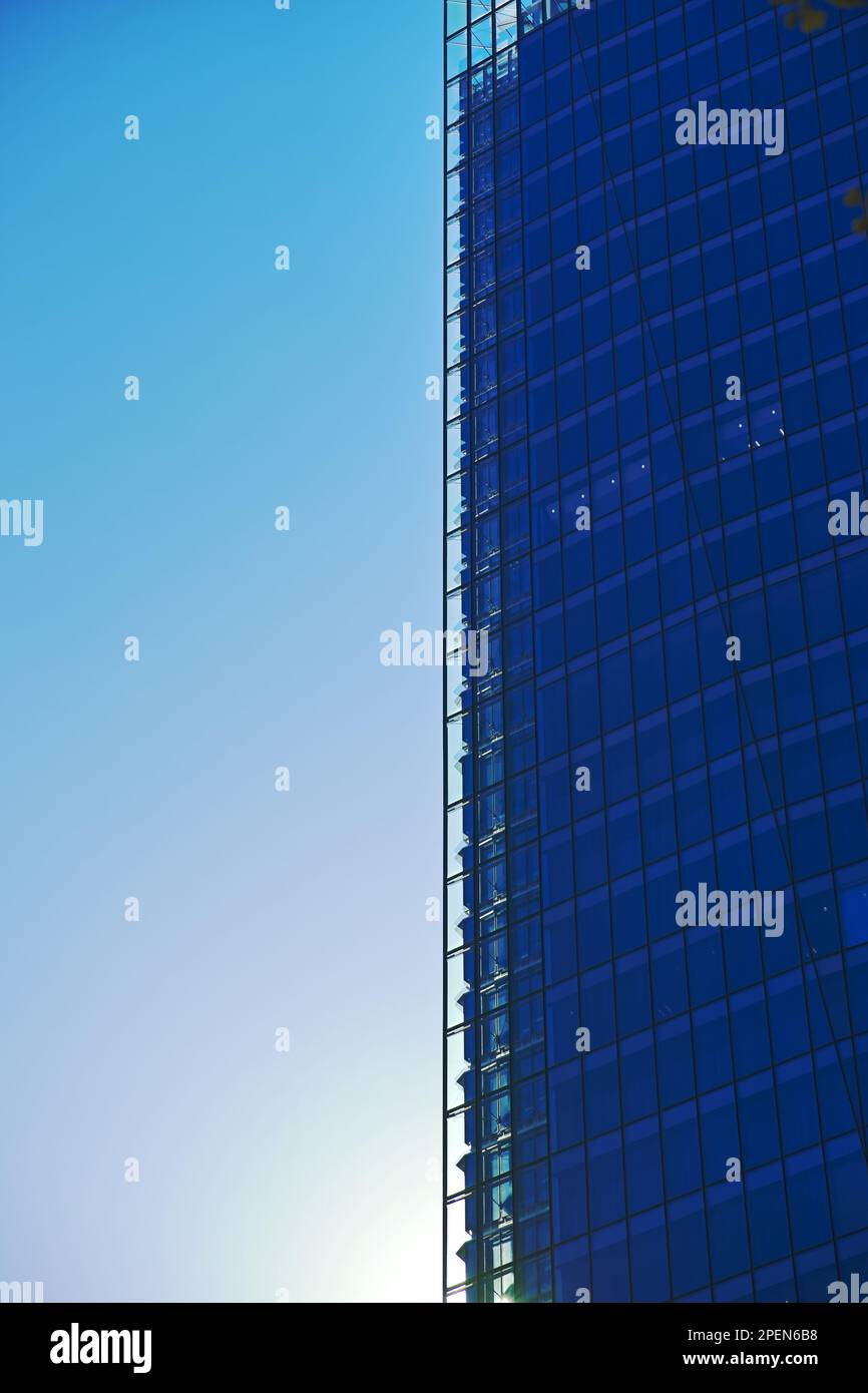 A modern glass and steel skyscraper against a blue sky Stock Photo - Alamy