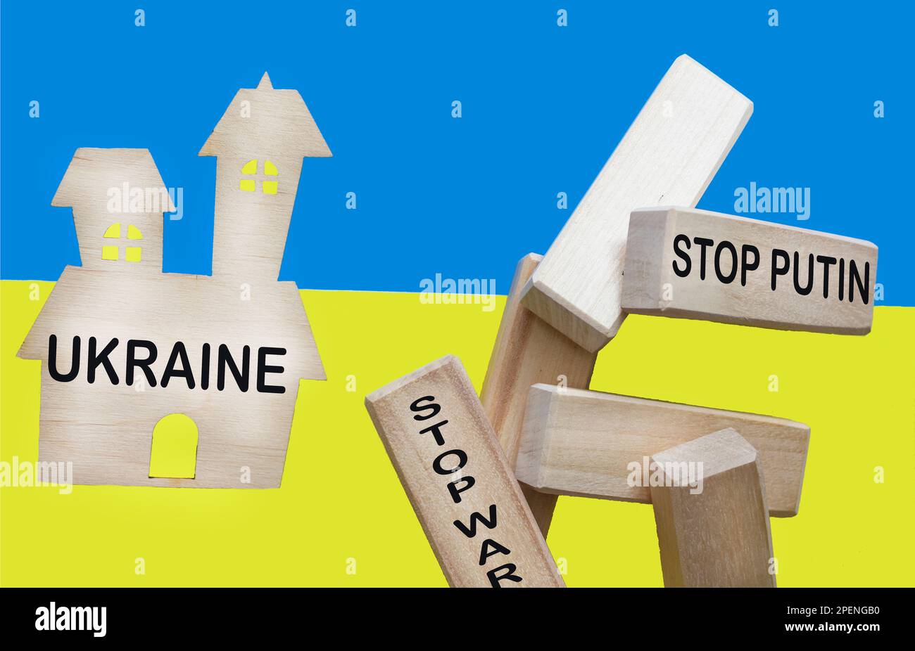 Model of a house and wooden blocks with the inscription STOP WAR and Stop Putin on the background of the Ukrainian flag. Stock Photo