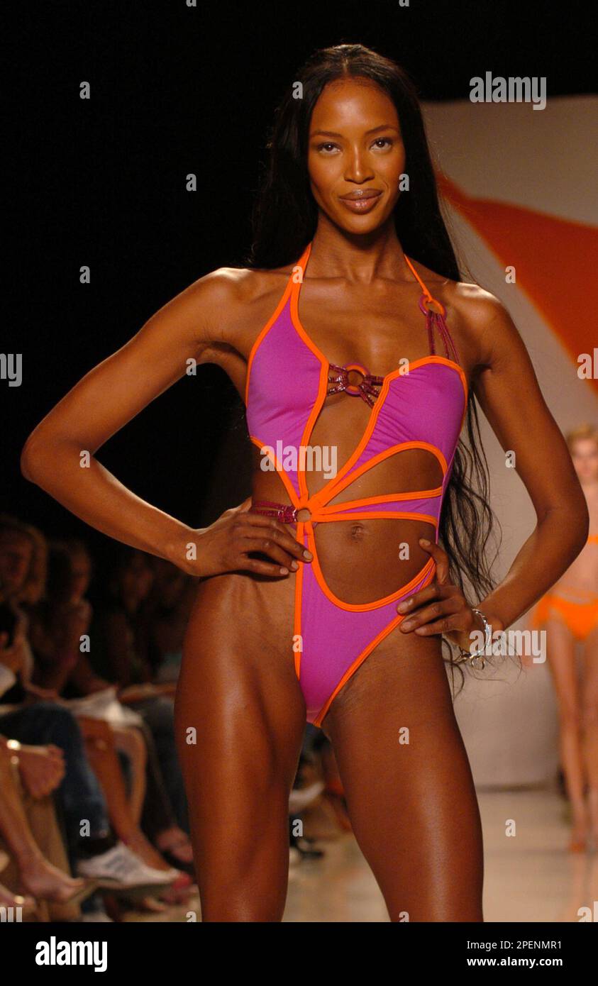 Naomi Campbell models a hot pink asymmetrical one piece bathing